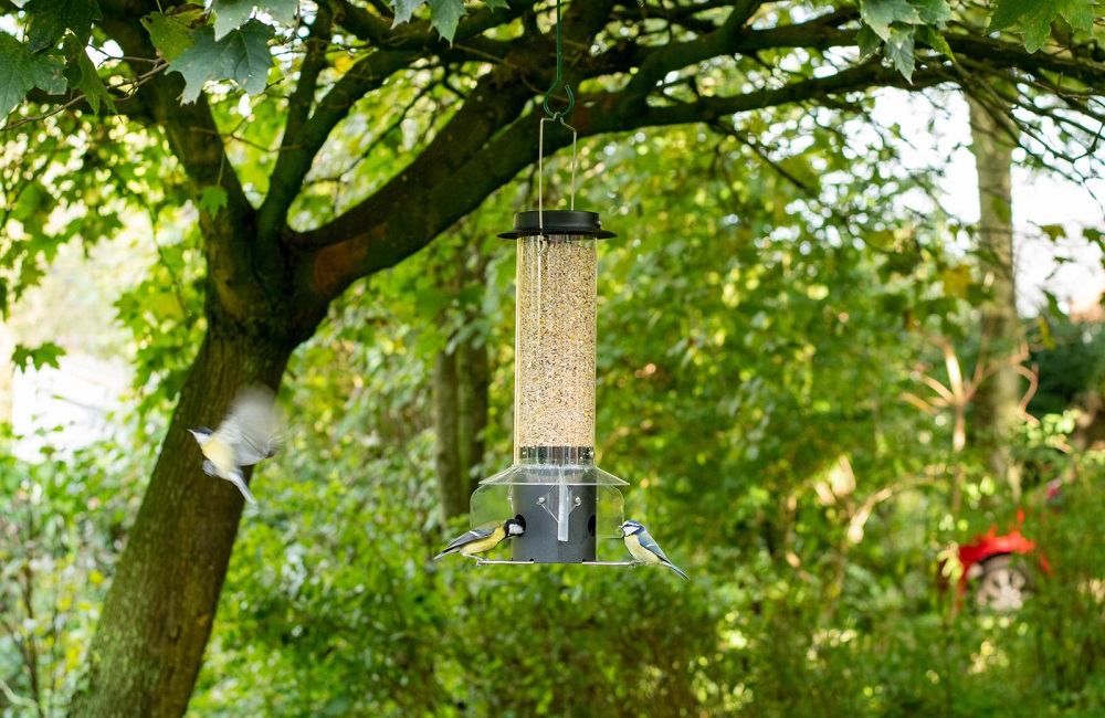 Child smiles while presenting the assembled nest box building kit